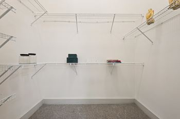 A white wall with metal shelves and a green box on the shelf.